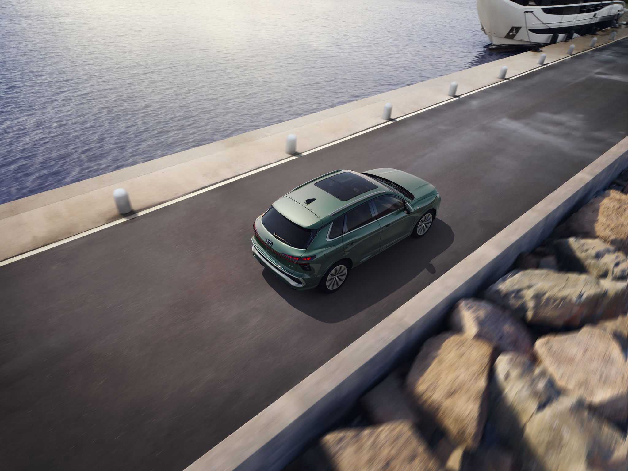 Audi Q3 SUV driving alongside a lake